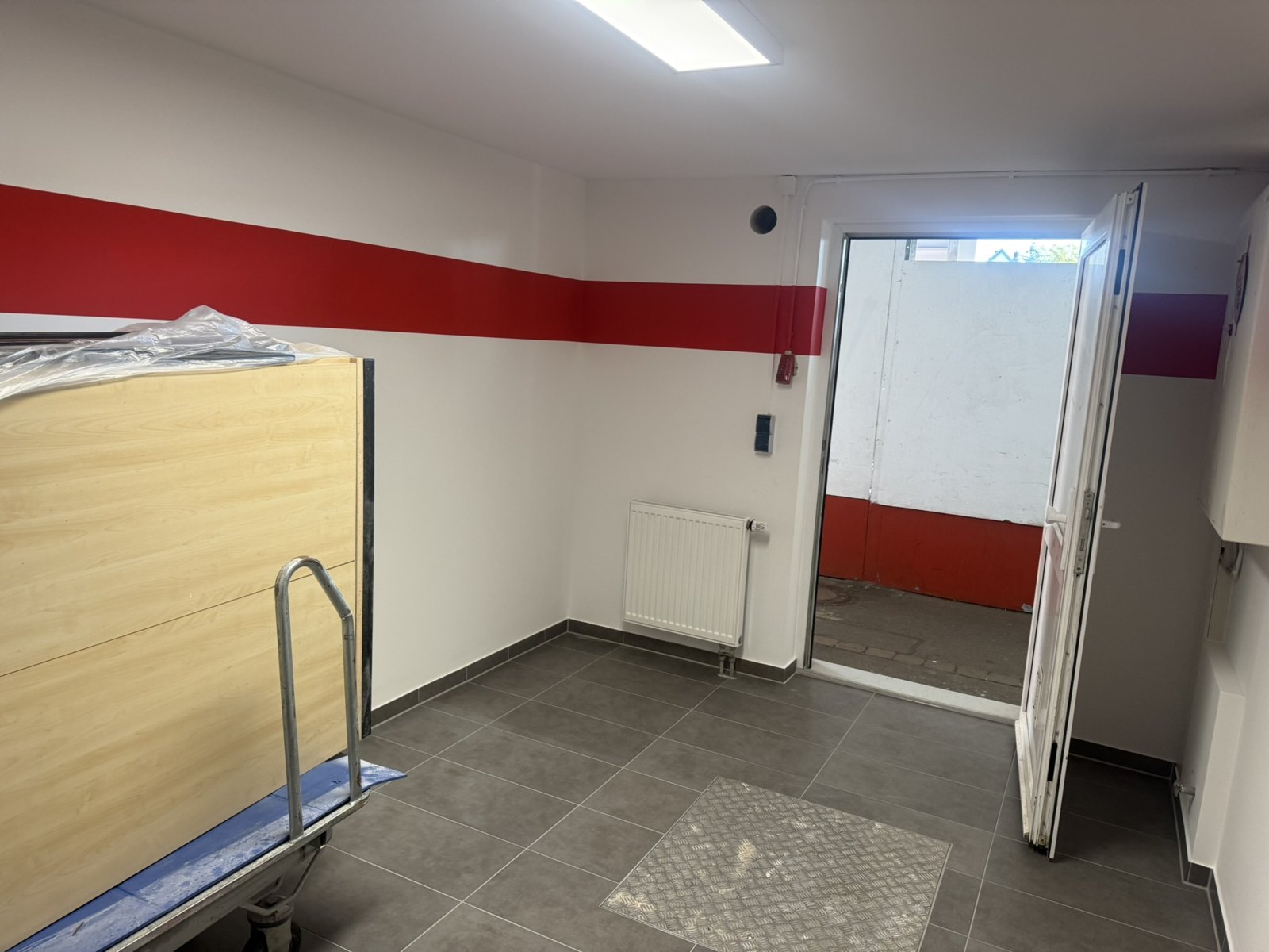 Ballraum am 8. August 2026 mit weißer Decke, Deckenleuchte und rotem Wandstreifen