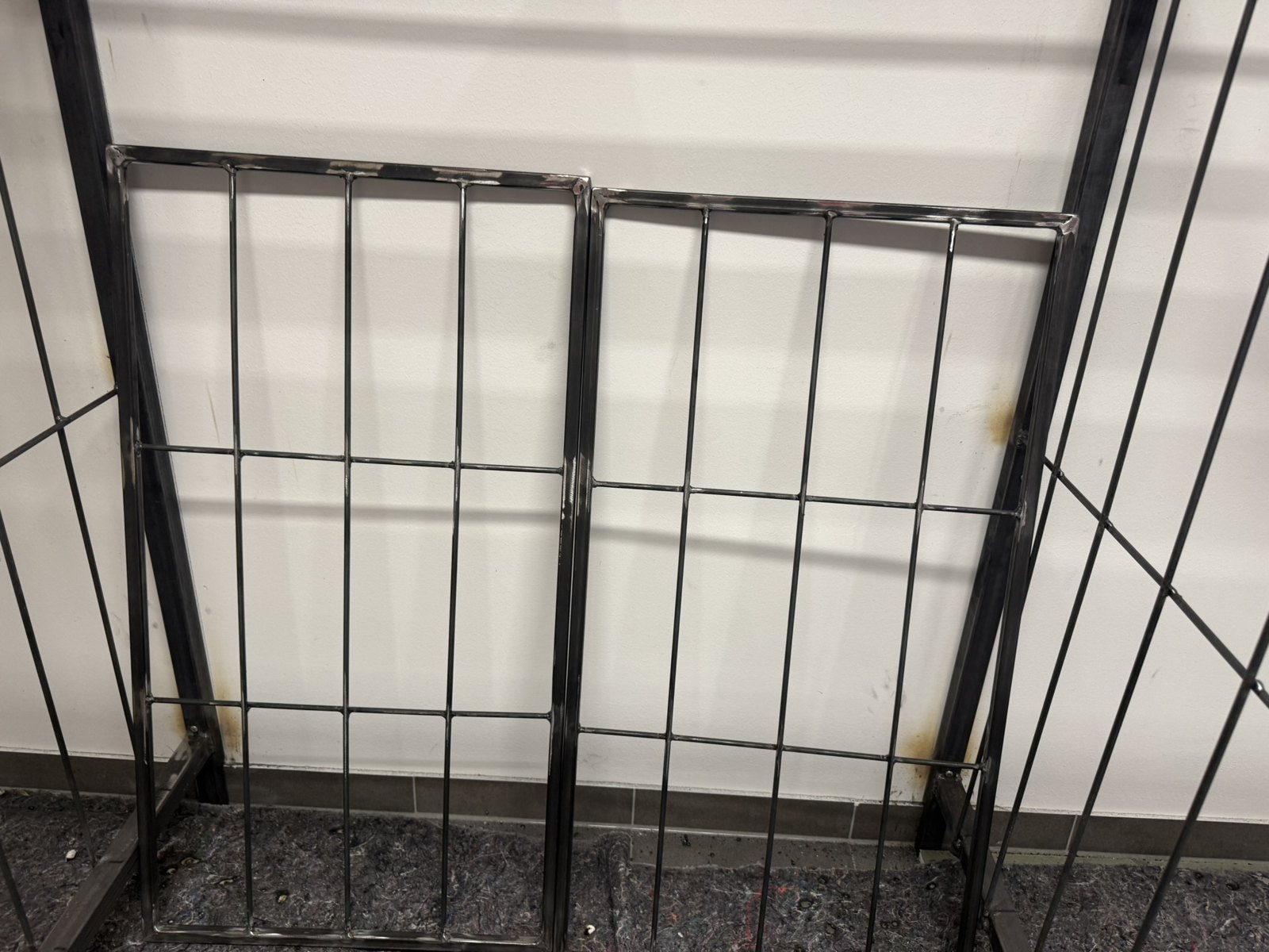 Detail der schwarzen Metallgestelle mit senkrechten Unterteilungen