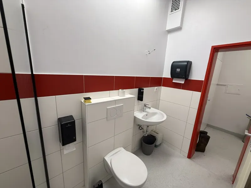Sanitärbereich mit WC, Waschbecken und Spendern